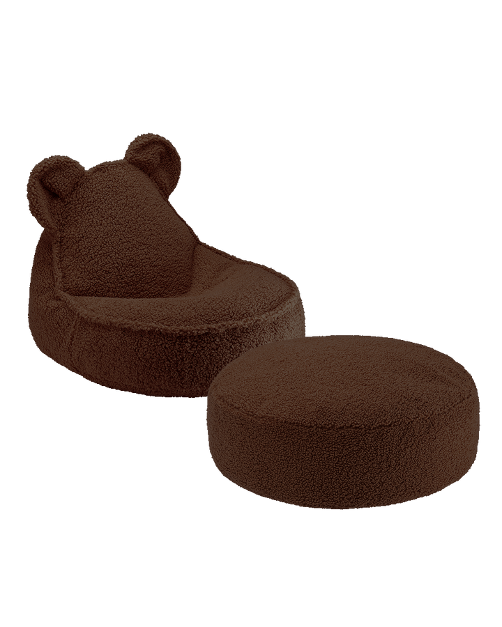 Dark brown Wigiwama bear chair and ottoman positioned with wooden shelving in modern interior