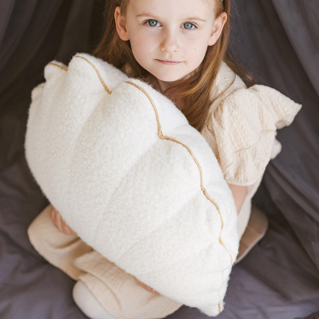 Ecru bouclé seashell cushion with golden metallic trim, front view