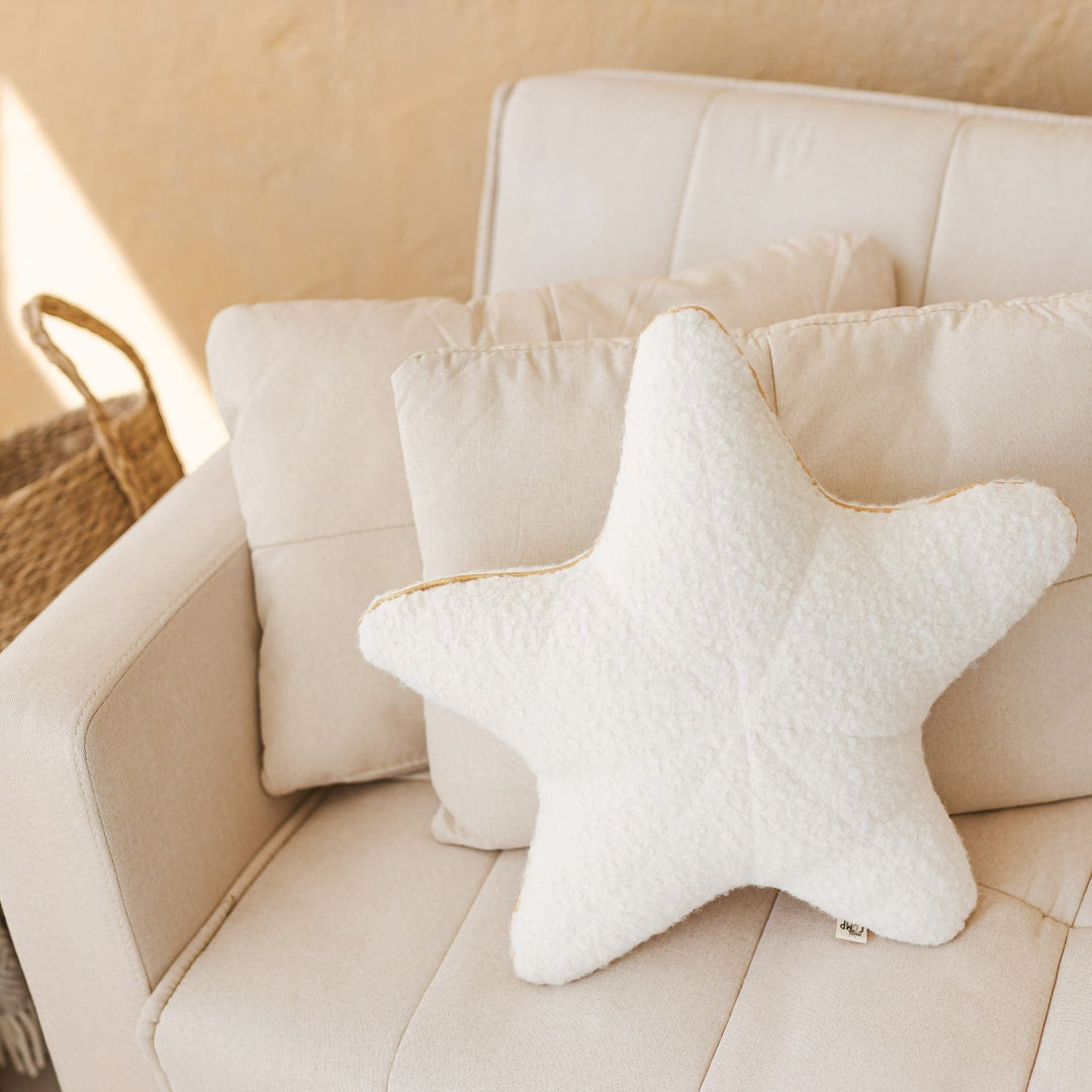 Ecru bouclé starfish cushion, angled view showing golden trim