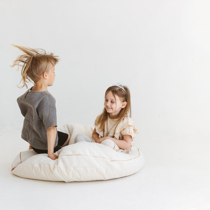 MINICAMP ecru boucle floor cushion, angled view