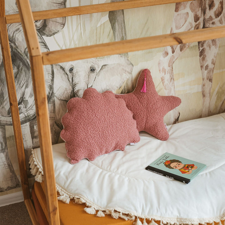 Rose bouclé seashell and starfish cushions styled together on a bed