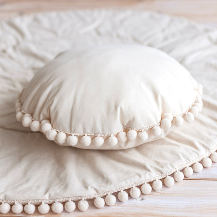 Close-up of the pompom trim on the MINICAMP Throw Pillow in Ecru