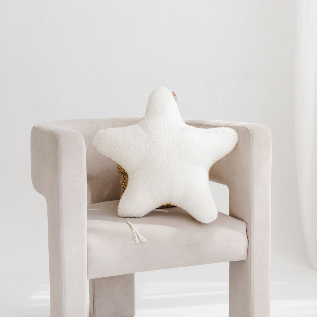 Ecru bouclé starfish cushion styled with matching cloud and round cushions on a bed