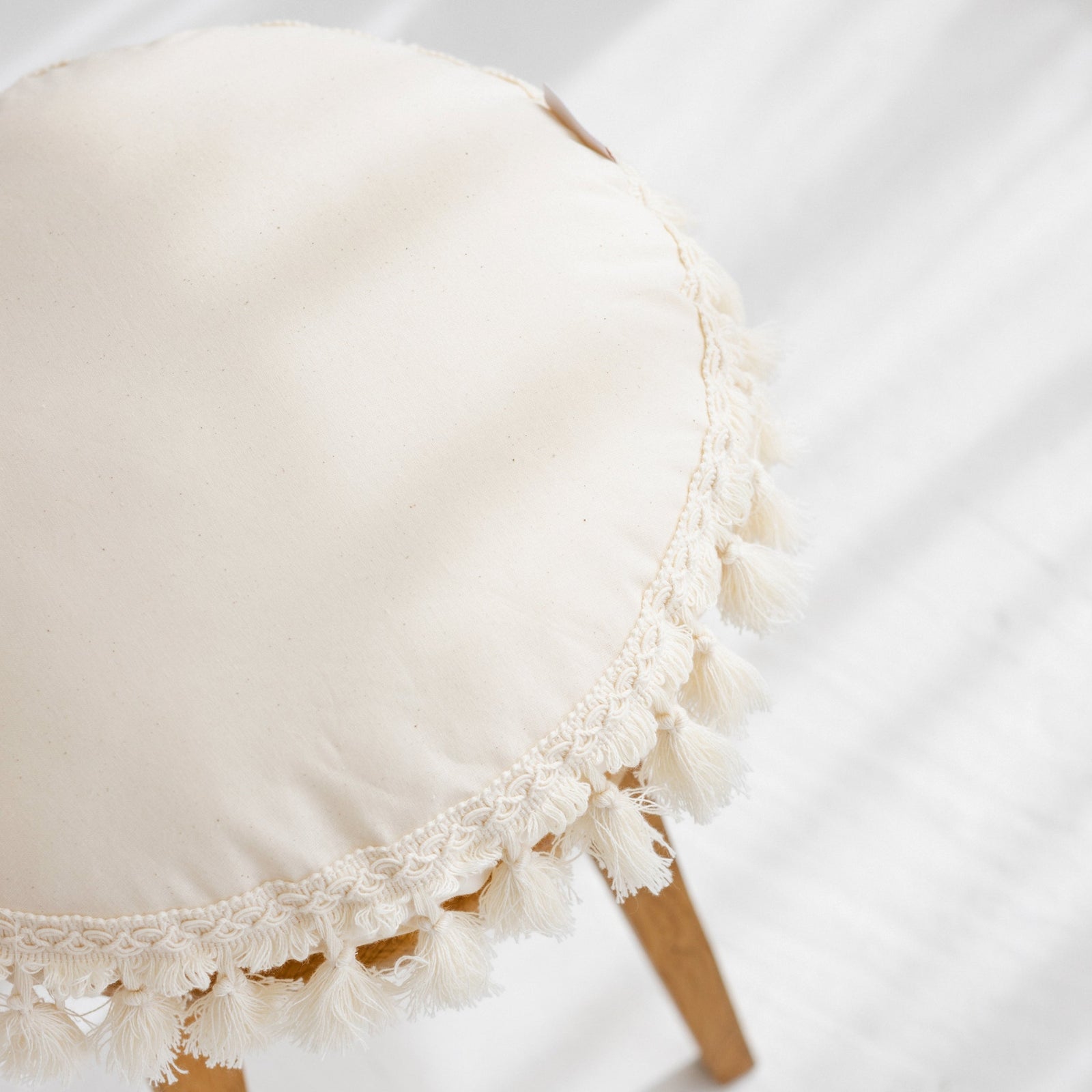 Close-up of the tassel trim on the MINICAMP Round Tassel Cushion