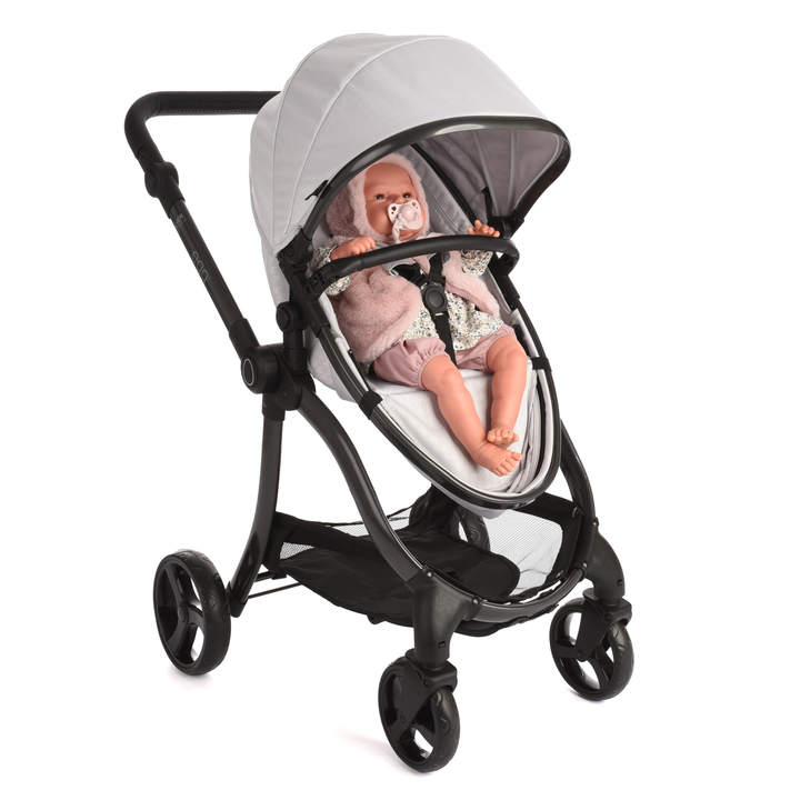 Roma Egg® Dolls Pram in Houndstooth Silver with a doll seated in the carrycot, fur accessories shown for styling (sold separately)