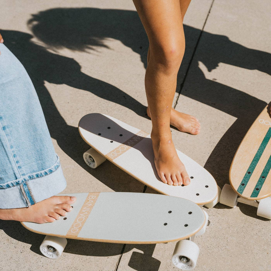 Banwood skateboard three-quarter view with white wheels and wooden edge detail