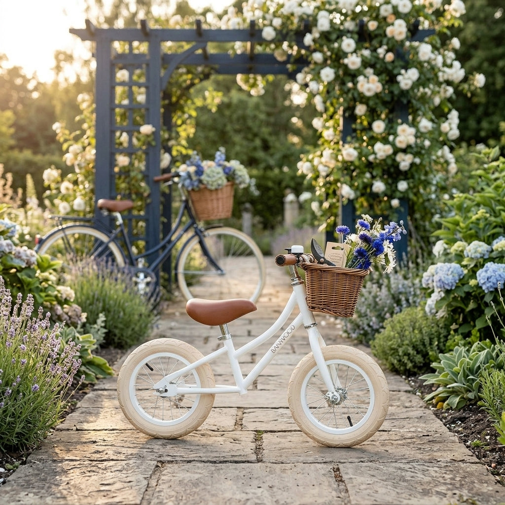 Banwood Balance Bike in White with wicker basket and bell, shown outdoors