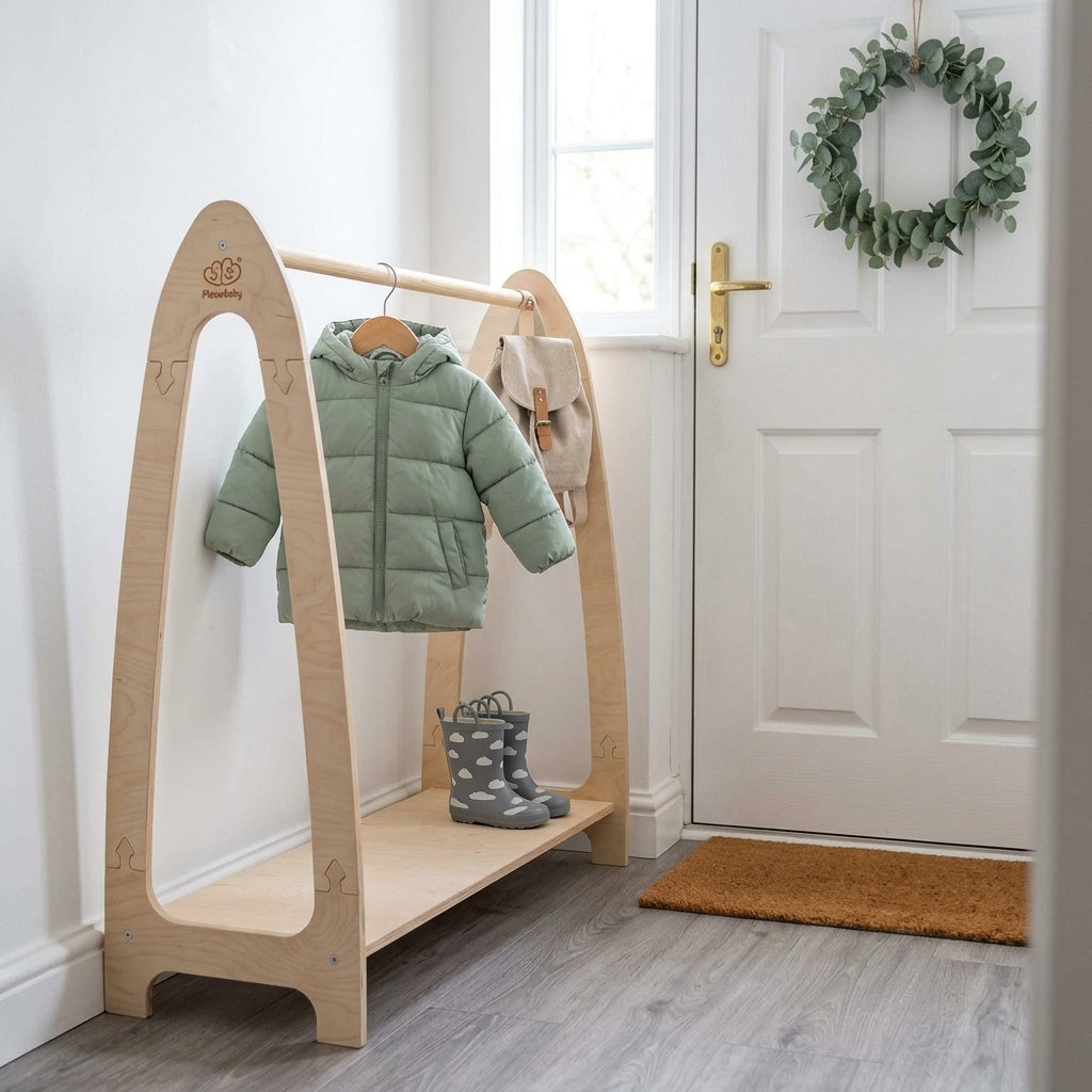 Child-height natural wooden coat stand with a coat, bag and wellies in a hallway