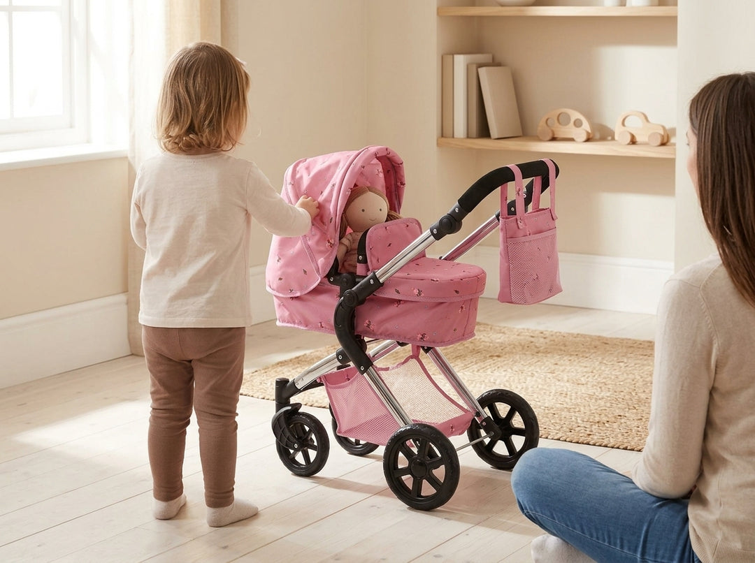 Young child beside the Roma Darcie Pink Dolls Pram with a doll in the carry cot, an adult watching nearby