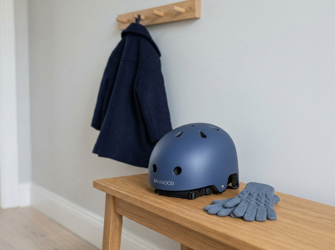 Banwood Classic Helmet in matte navy on a hallway bench next to children's gloves
