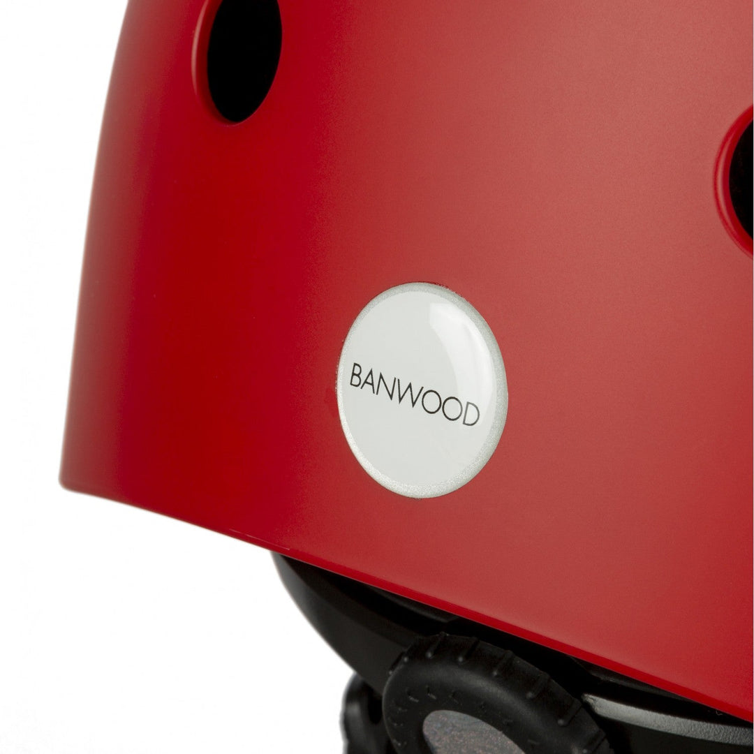 Close-up of the Banwood logo badge on the Matte Red Classic Helmet