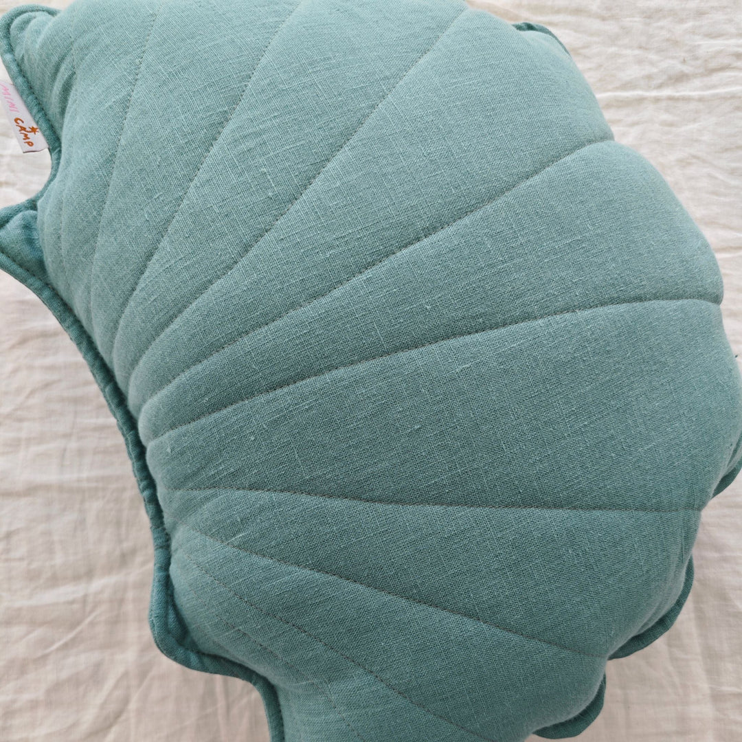 Close-up of mint linen fabric and quilted stitching on seashell cushion
