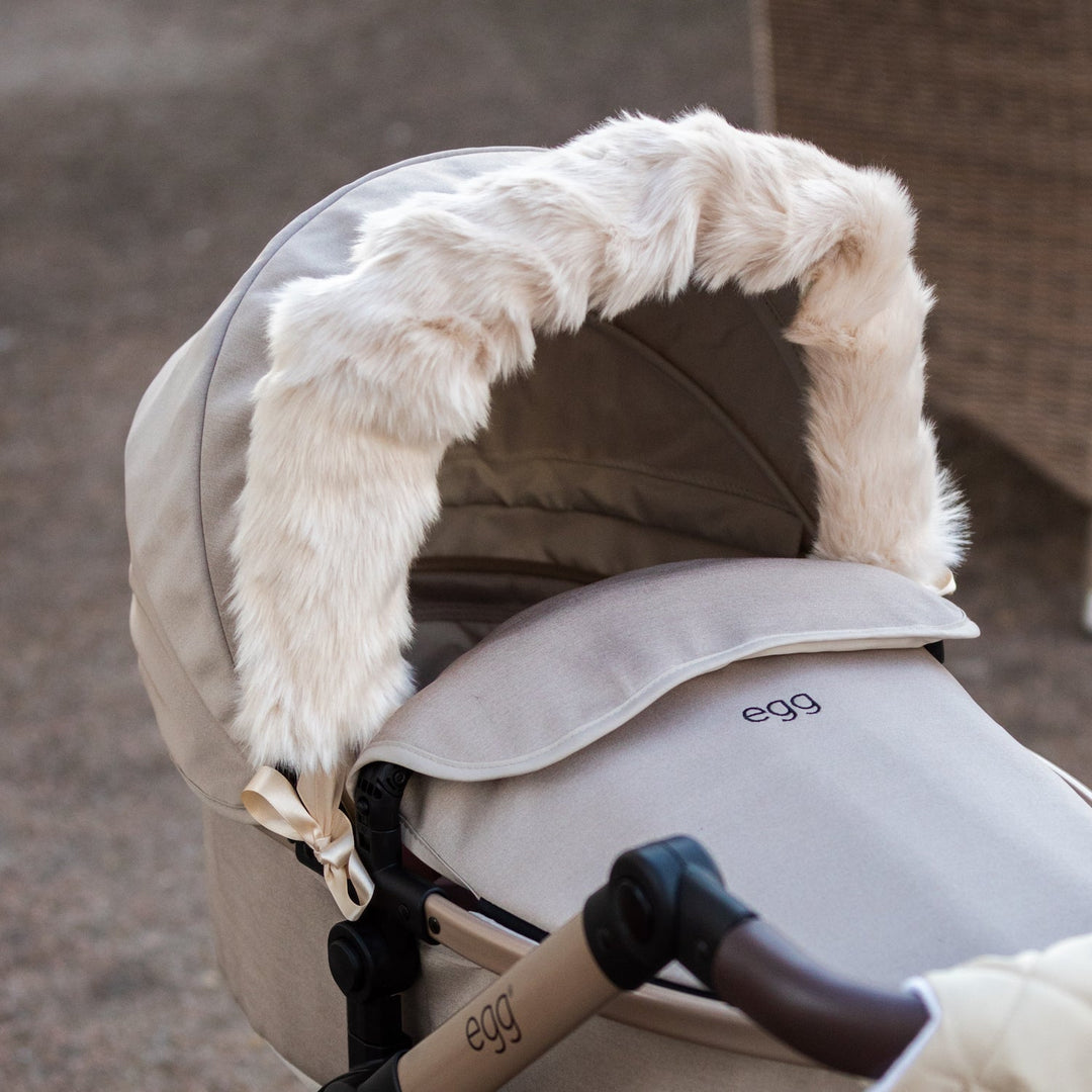 Roma Dolls Pram Hood Fur in feather colourway, ribbon-tied to an egg dolls pram hood