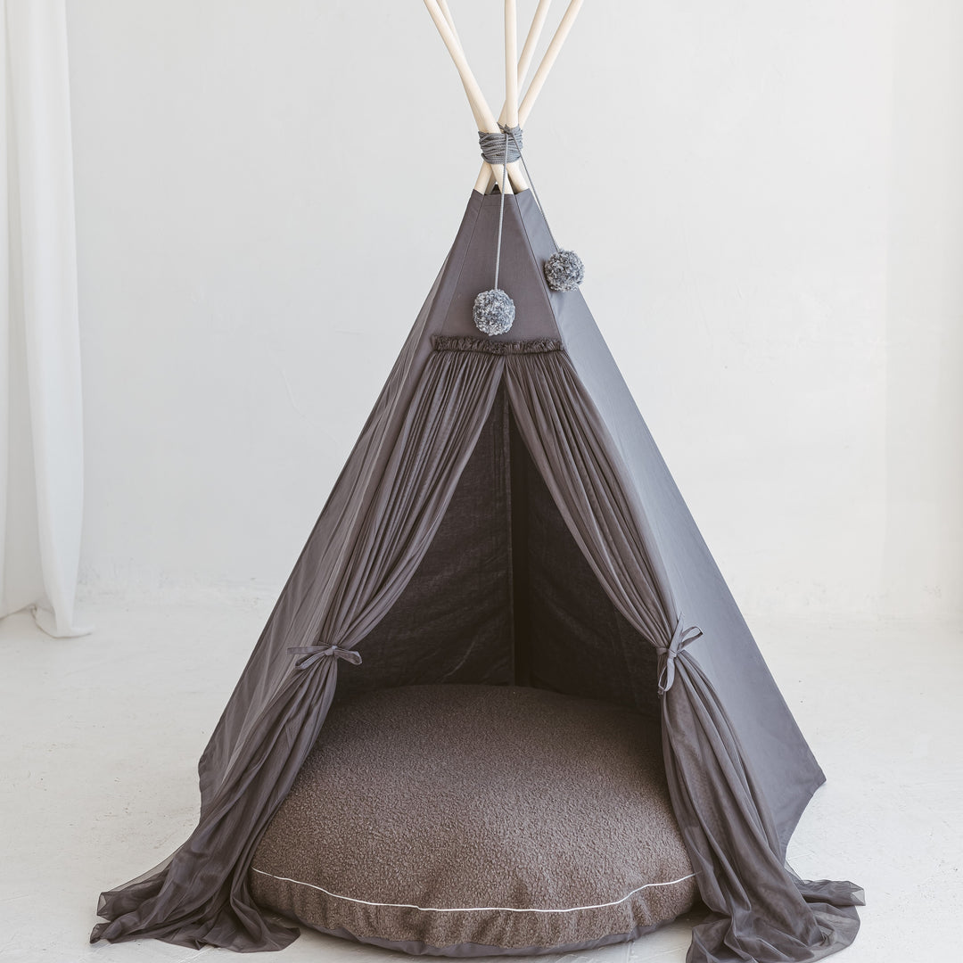 A grey MINICAMP play teepee with a matching grey boucle floor cushion