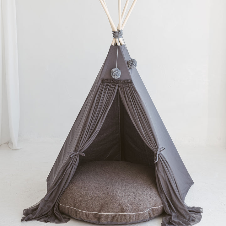 A grey MINICAMP play teepee with a matching grey boucle floor cushion