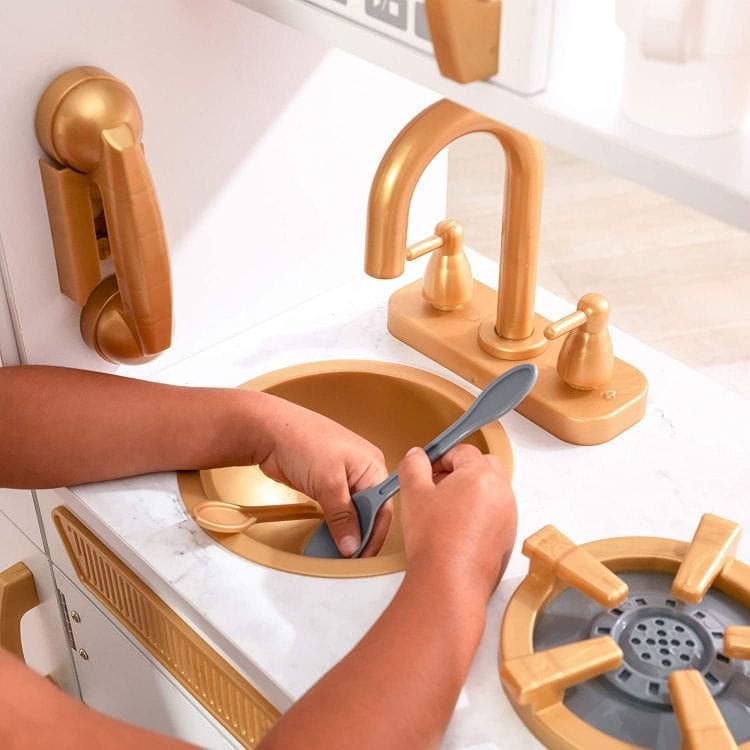 Close-up of a child washing a spoon at the MeowBaby White &amp; Gold Wooden Play Kitchen sink