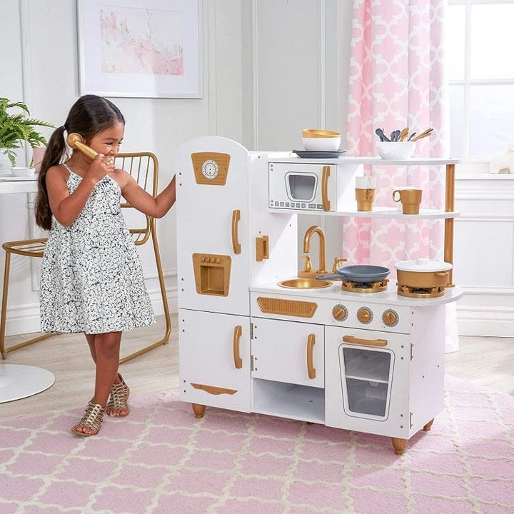A child playing with a play telephone beside the MeowBaby White &amp; Gold Wooden Play Kitchen