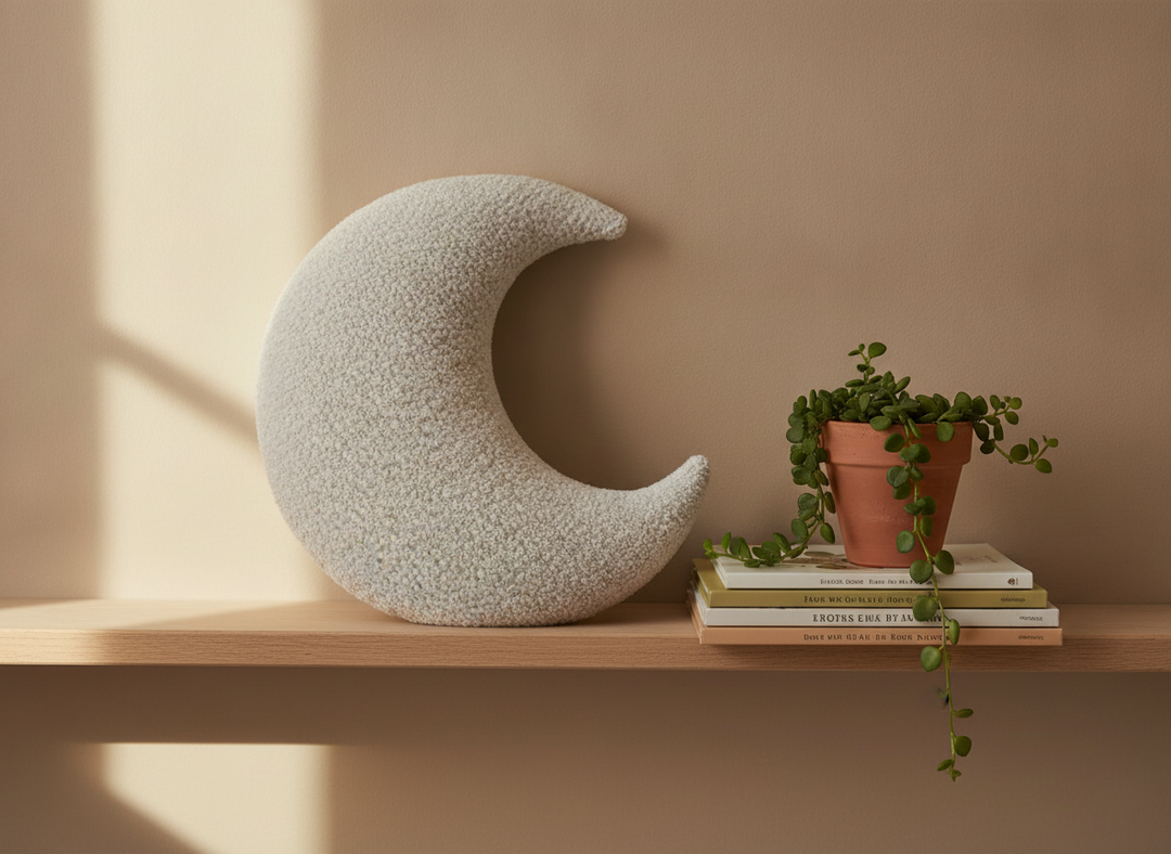 MeowBaby Moon Decorative Pillow in White propped on a nursery shelf beside picture books